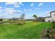 Green backyard lawn with pond view and screened enclosure at 16439 Slate Pl, Bradenton, FL 34211