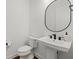 Modern bathroom with pedestal sink, oval mirror, and dark accents at 16439 Slate Pl, Bradenton, FL 34211