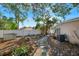 A backyard with a stone pathway, mature trees, and a white fence at 2416 Amherst Ave, Bradenton, FL 34207