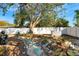 A backyard with a stone pathway, mature trees, and a white fence at 2416 Amherst Ave, Bradenton, FL 34207