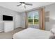 Bedroom with TV, dresser, and view of wooded area at 2471 Midnight Pearl Dr, Sarasota, FL 34240