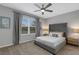 Spacious bedroom with gray upholstered bed, ceiling fan, and window at 2471 Midnight Pearl Dr, Sarasota, FL 34240