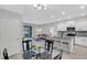 Open concept dining area with glass table and view into living room at 2471 Midnight Pearl Dr, Sarasota, FL 34240