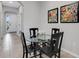 Bright dining area with glass table and four black chairs, view of entryway at 2471 Midnight Pearl Dr, Sarasota, FL 34240