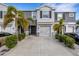 Two-story townhome with gray siding, two-car garage, and palm trees at 2471 Midnight Pearl Dr, Sarasota, FL 34240