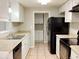 Modern kitchen with white cabinets, black appliances, and tile floors at 320 Cardinal Rd, Venice, FL 34293