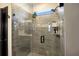 Spa-like shower with glass enclosure, gray tile, and built-in shelving at 3324 Big Sky Way, Lakewood Ranch, FL 34211