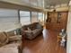 Bright sunroom with laminate floors, brown couches, and built-in shelving at 3333 26Th E Ave # 1150, Bradenton, FL 34208