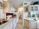 Galley kitchen with white cabinets and a view into dining area at 3333 26Th E Ave # 1155, Bradenton, FL 34208