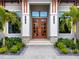 Modern entryway with double wood doors, stone accents, and lush landscaping at 3354 Founders Club Dr, Sarasota, FL 34240