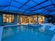 Inviting pool and spa with covered lanai at dusk at 3354 Founders Club Dr, Sarasota, FL 34240