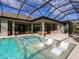 Stunning pool and spa with covered patio and adjacent outdoor kitchen at 3354 Founders Club Dr, Sarasota, FL 34240