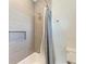 Shower stall with gray tile and a white tub at 3761 Founders Club Dr, Sarasota, FL 34240