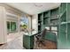 Home office with built-in green shelving and glass-top desk at 3761 Founders Club Dr, Sarasota, FL 34240