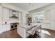 Bright kitchen with white cabinets, granite island, and hardwood floors at 3761 Founders Club Dr, Sarasota, FL 34240