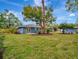 Large backyard with a grassy area and mature trees at 3902 11Th W Ave, Bradenton, FL 34205