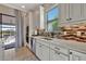 Bright kitchen with white cabinets, stainless steel appliances, and views to backyard at 4020 Cascina Way, Sarasota, FL 34238