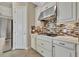 Kitchen features white cabinets, gas cooktop, and a mosaic backsplash at 4020 Cascina Way, Sarasota, FL 34238