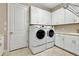 Bright laundry room with washer, dryer, and ample cabinets at 4020 Cascina Way, Sarasota, FL 34238