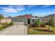 One-story home with gray siding, stone accents, and a two-car garage at 4110 Mossy Limb Ct, Palmetto, FL 34221