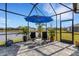 Peaceful screened patio with lake view and seating area at 4110 Mossy Limb Ct, Palmetto, FL 34221