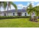 Single story home with manicured lawn and palm trees at 5006 W Country Club Dr, Sarasota, FL 34243