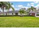 Single story home with lush landscaping and palm trees at 5006 W Country Club Dr, Sarasota, FL 34243