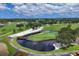 Aerial view of a lush green golf course with a water feature at 5006 W Country Club Dr, Sarasota, FL 34243