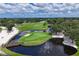 Aerial view of a serene golf course with a water feature and bridge at 5006 W Country Club Dr, Sarasota, FL 34243