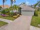 Landscaped home exterior with brick driveway and palm trees at 6234 Sturbridge Ct, Sarasota, FL 34238