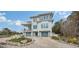 Two story home with gray garage doors and nicely landscaped yard at 625 Jackson Way, Longboat Key, FL 34228