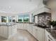 Modern kitchen featuring granite countertops, white cabinetry, and a large island at 675 Longboat Club Rd # 22A, Longboat Key, FL 34228