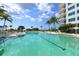 Resort-style pool with lounge chairs and palm trees at 675 Longboat Club Rd # 22A, Longboat Key, FL 34228