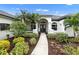 Front entrance with arched entryway, columns, and lush landscaping at 7117 River Club Blvd, Bradenton, FL 34202