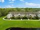 Row of tan townhouses with green roofs and a pond at 7417 Vista Way # 106, Bradenton, FL 34202