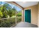 Screened porch with view of lush landscaping and a teal door at 7417 Vista Way # 106, Bradenton, FL 34202