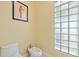 Small bathroom with toilet and bidet, featuring a glass block window at 7716 Club Ln, Sarasota, FL 34238