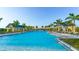 Large community pool with lounge chairs and palm trees at 8052 Grande Shores Dr, Sarasota, FL 34240