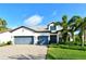 Two-story house with gray-blue garage doors and nicely landscaped lawn at 8052 Grande Shores Dr, Sarasota, FL 34240