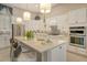 Modern kitchen with white cabinets, center island, and stainless steel appliances at 8052 Grande Shores Dr, Sarasota, FL 34240