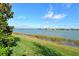 Scenic lake view from backyard with lush green grass at 8052 Grande Shores Dr, Sarasota, FL 34240