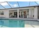 Expansive pool and patio with outdoor kitchen and lake view at 8052 Grande Shores Dr, Sarasota, FL 34240