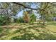 Expansive backyard with mature trees providing shade and privacy at 8628 Woodbriar Dr, Sarasota, FL 34238