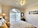 Bright bedroom with arched window, ceiling fan, and comfortable bedding at 8752 Monterey Bay Loop, Bradenton, FL 34212