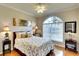 Guest bedroom with wooden bed frame and arched window at 8752 Monterey Bay Loop, Bradenton, FL 34212