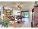 Spacious living room with leather furniture, a ceiling fan, and large windows at 8752 Monterey Bay Loop, Bradenton, FL 34212