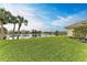 Large backyard with lush grass and a tranquil lake view at 115 Grand Oak Cir, Venice, FL 34292