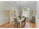 Elegant dining room with hardwood floors, a glass-top table, and a china cabinet at 115 Grand Oak Cir, Venice, FL 34292