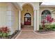 Entryway with a charming red door and a welcoming bench at 115 Grand Oak Cir, Venice, FL 34292
