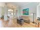 Light-filled living room features hardwood floors and a comfortable leather couch at 115 Grand Oak Cir, Venice, FL 34292